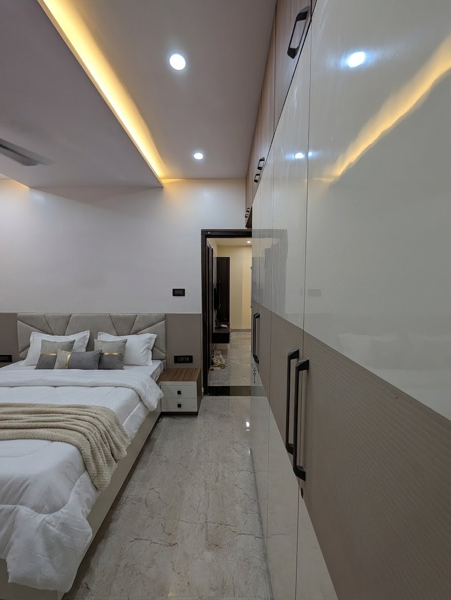 Modern luxury bedroom interior design featuring a wooden slat accent wall, upholstered bed, pendant lighting, warm ambient lighting, custom furniture, and contemporary decor by Aim Interiors in Kolkata and Howrah.