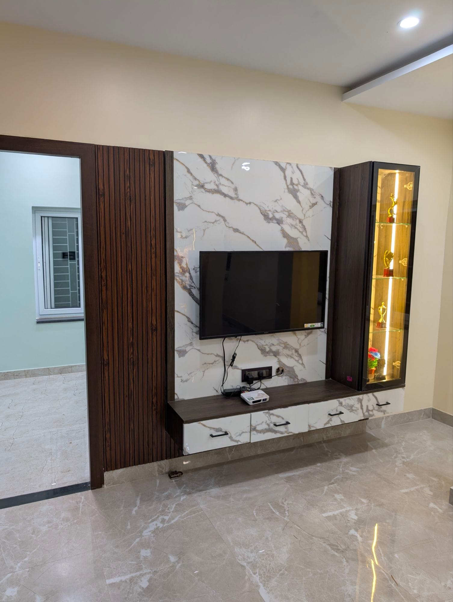 Textured stone-finish wardrobe with brass inlay detailing in Dumdum home interior project, Kolkata
